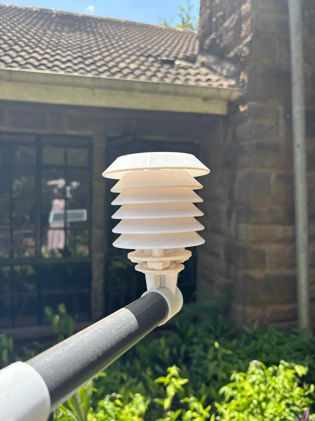 Close view of a weather station sensor shield on its arm